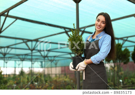 Female business owner with potted plant in greenhouse. Space for text Female business owner with potted plant in greenhouse. Space for text 89835173
