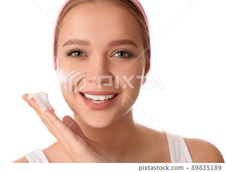 Young woman washing face with cleansing foam on white background. Cosmetic product Young woman washing face with cleansing foam on white background. Cosmetic product 89835189