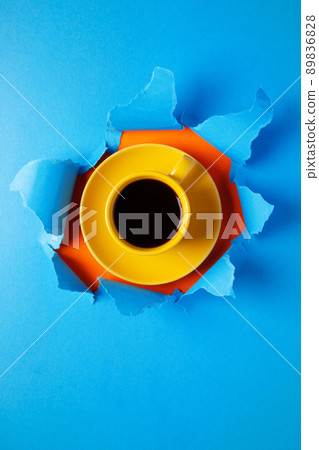 Cup of coffee in torn paper. Coffee espresso on jeans background 89836828