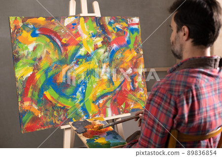Male artist working with painting. Man artist painter and palettte in creative studio 89836854
