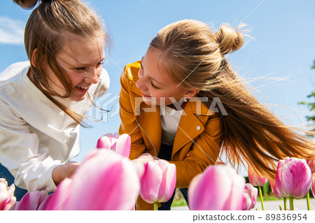 Two teenager girls look at each other with smiles. 89836954