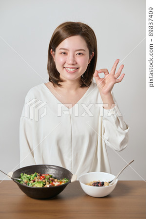 Young woman posing OK before eating salad and oatmeal 89837409