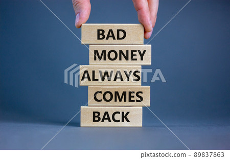 Business concept growth success process. Wood blocks on grey background, copy space. Businessman hand. Words 'bad money always comes back'. Conceptual image of motivation. 89837863