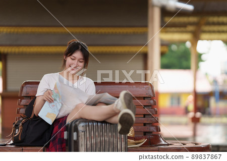 Pretty Young traveler woman looking on maps planning trip at train station. Summer and travel lifestyle concept. 89837867