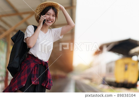 Young traveler woman looking for friend planning trip at train station. Summer and travel lifestyle concept. 89838104
