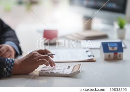 Banker or agent calculate house cost and make agreement contract. Real Estate concept. Banker or agent calculate house cost and make agreement contract. Real Estate concept. 89838293