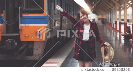 Happy Young traveler woman looking for friend planning trip at train station. Summer and travel lifestyle concept. 89838298