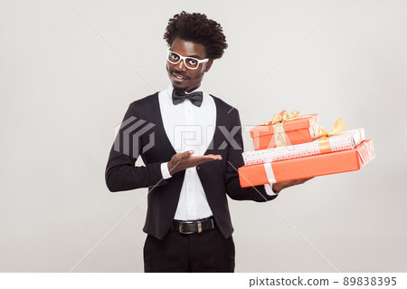 Valentine day concept. African businessman pointing hand at red box. Studio shot, gray background Valentine day concept. African businessman pointing hand at red box. Studio shot, gray background 89838395