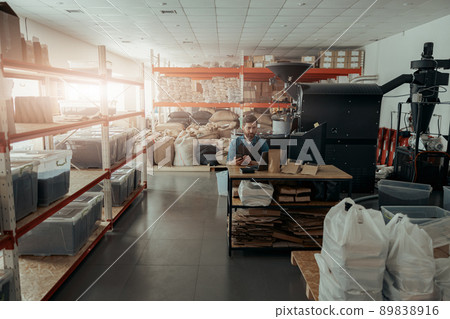 Business owner of small coffee roasting factory working on his workplace Business owner of small coffee roasting factory working on his workplace 89838916