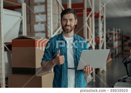Warehouse worker standing with laptop on manufacturing and raise his finger up Warehouse worker standing with laptop on manufacturing and raise his finger up 89838920