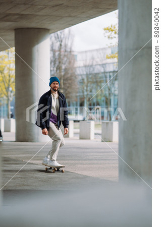 Portrait of active skater boy balancing on skateboard on urban background Focused skateboarder moving on skate board outdoor. 89840042