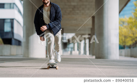 Portrait of active skater boy balancing on skateboard on urban background Focused skateboarder moving on skate board outdoor. 89840058