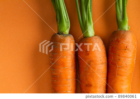 Flat lay top view composition with bio carrots on orange background. copy space Flat lay top view composition with bio carrots on orange background. copy space 89840061