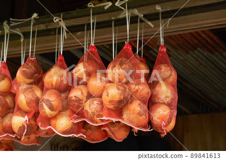 Onions hung in the net for long-term storage 89841613