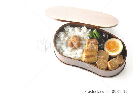 A bird's-eye view of a bento bento box containing black beans, spinach, and soft-boiled eggs on a white background. A bird's-eye view of a bento bento box containing black beans, spinach, and soft-boiled eggs on a white background. 89841991