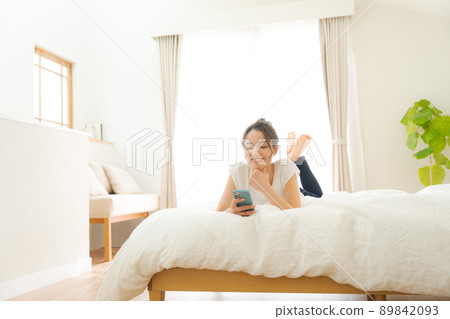 A woman relaxing in bed A woman relaxing in bed 89842093