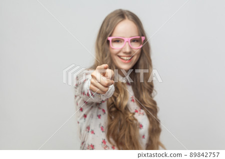Hey you!You cool! Teenager girl, pointing finger at camera and toothy smiling. Studio shot, isolated on gray background Hey you!You cool! Teenager girl, pointing finger at camera and toothy smiling. Studio shot, isolated on gray background 89842757