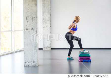 Blonde woman practice on step platform. Studio shot Blonde woman practice on step platform. Studio shot 89842856