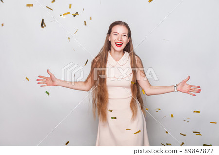 Happiness long haired blonde woman in pink dress, looking at camera and toothy smiling. Studio shot. Gray background Happiness long haired blonde woman in pink dress, looking at camera and toothy smiling. Studio shot. Gray background 89842872