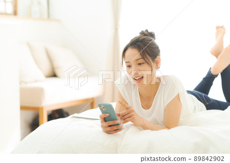 A woman relaxing in bed 89842902