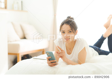 A woman relaxing in bed 89842906