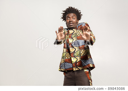 Fear concept. Confused african man scared and panic. Indoor, isolated on gray background Fear concept. Confused african man scared and panic. Indoor, isolated on gray background 89843086