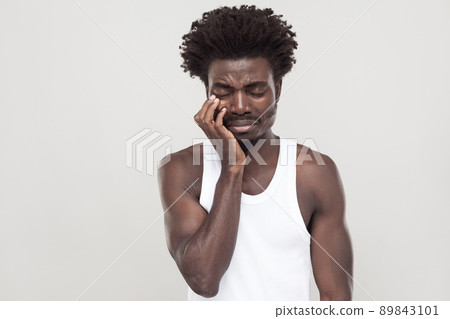 Closed eyes and cry. Unhappy afro man with souvarov mustache, cry and have depression. Indoor shot Closed eyes and cry. Unhappy afro man with souvarov mustache, cry and have depression. Indoor shot 89843101