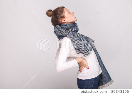 Profile view sick woman which hurts the back or kidneys. Indoor shot Profile view sick woman which hurts the back or kidneys. Indoor shot 89843106