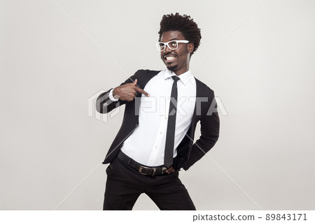 Well dressed proud man pointing finger himself. Studio shot, gray background 89843171