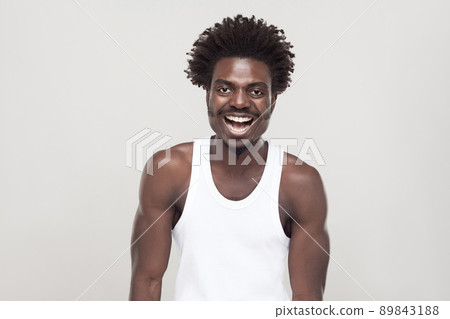 Laughing and positive concept. Man looking at camera and smiling. Studio shot. Gray background Laughing and positive concept. Man looking at camera and smiling. Studio shot. Gray background 89843188
