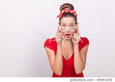 Expression surprise beautiful woman with shocked face, in dress, bandsge. Indoor, studio shot, isolated on gray background Expression surprise beautiful woman with shocked face, in dress, bandsge. Indoor, studio shot, isolated on gray background 89843200