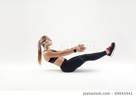 Woman in sportswear doing pilates exercising. Indoor shot, gray background 89843441