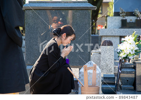 A bereaved woman (gassho) visiting a grave A bereaved woman (gassho) visiting a grave 89843487