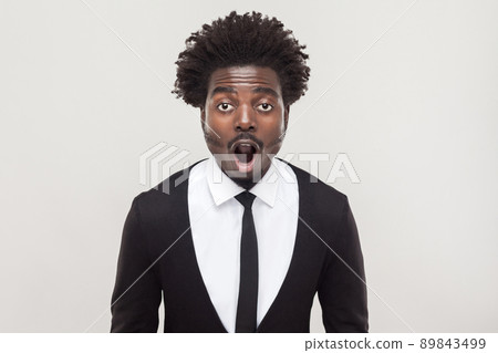 Amazement businessman looking at camera with shocked face. Studio shot, gray background Amazement businessman looking at camera with shocked face. Studio shot, gray background 89843499