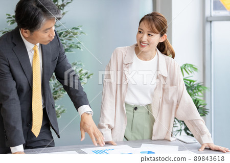 Two business people holding a standing meeting 89843618