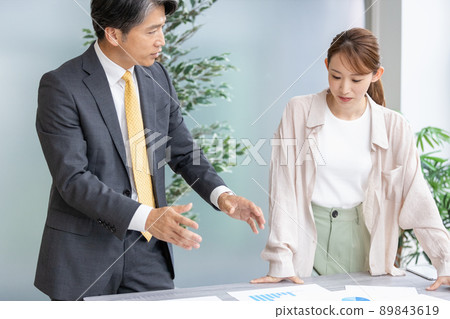 Two business people holding a standing meeting 89843619