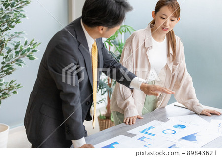 Two business people holding a standing meeting Two business people holding a standing meeting 89843621