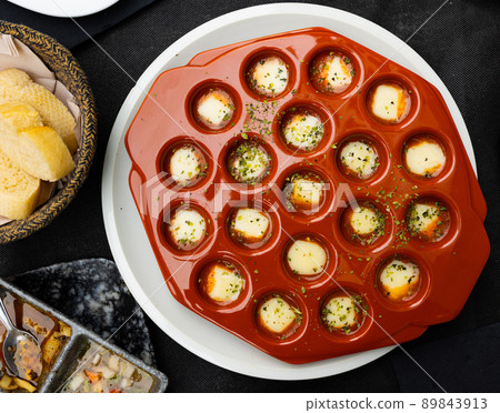 Spicy oven-baked Provolone cheese in ceramic baking dish Spicy oven-baked Provolone cheese in ceramic baking dish 89843913