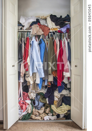 messy closet overfilled with clothes 89845045