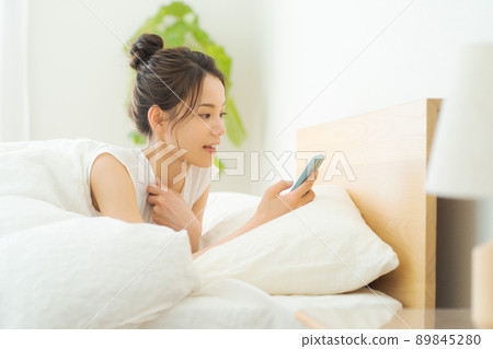 A woman in her 20s relaxing in bed 89845280