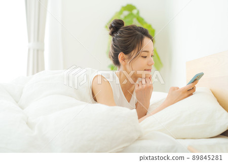 A woman in her 20s relaxing in bed 89845281