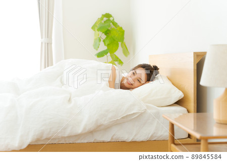 一個 20 多歲的女人在床上放鬆 89845584