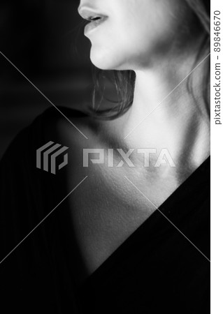 Young tender well-groomed woman's neck in a photo in black and white. Vertical photo. 89846670