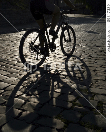 Cyclist rides along a city street 89847329