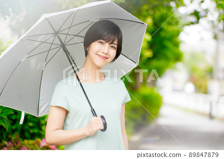 拿著遮陽傘的一個少婦 拿著遮陽傘的一個少婦 89847879