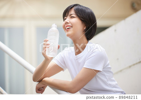 在塑料瓶的一個少婦飲用水 在塑料瓶的一個少婦飲用水 89848211