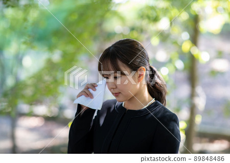 一個女人在葬禮上用手帕哭泣 89848486