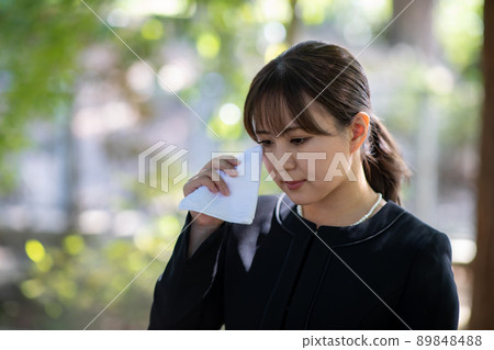 一個女人在葬禮上用手帕哭泣 89848488