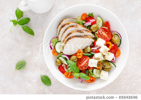 Grilled chicken breast and fresh greek salad with feta cheese. Top view 89848696