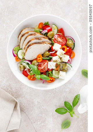 Grilled chicken breast and fresh greek salad with feta cheese. Top view 89848697